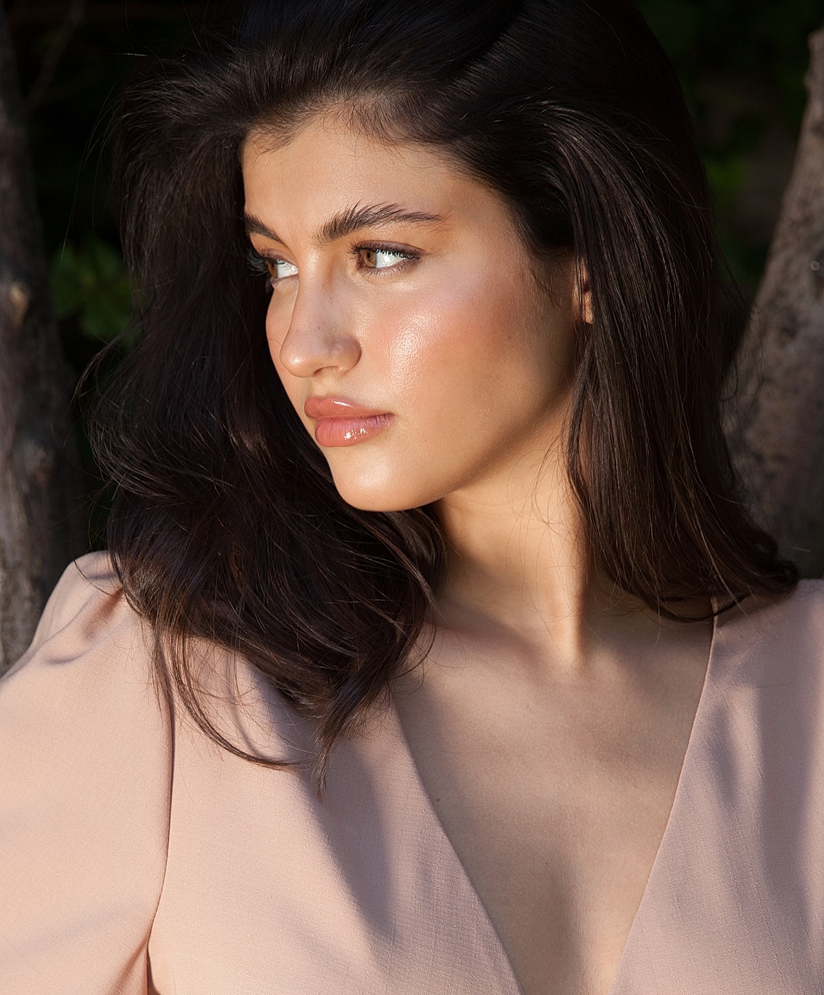 Woman with long hair, soft lighting, serene expression.