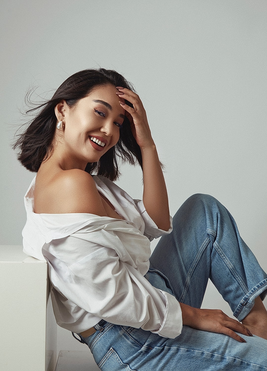Smiling woman in casual outfit, playful pose.
