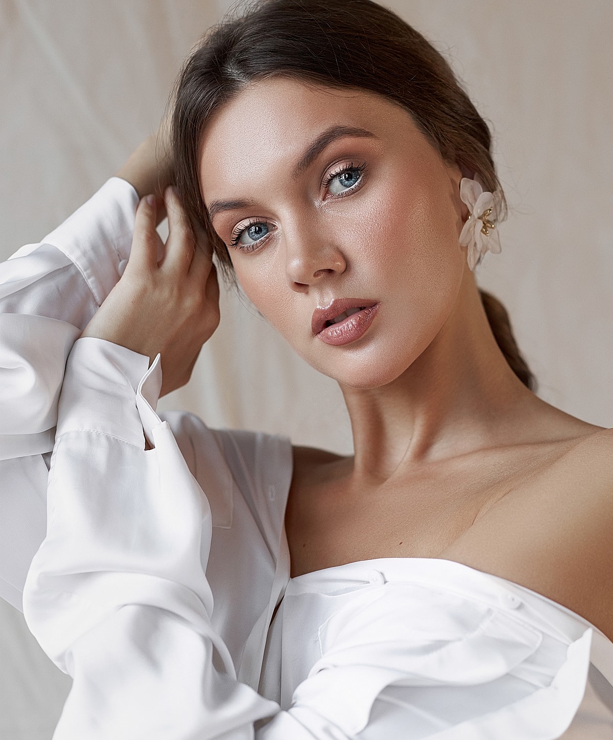 Woman with styled hair and white blouse.