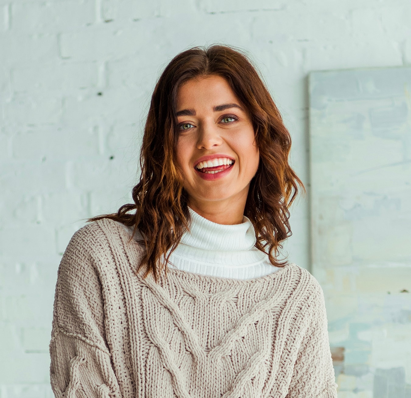 Smiling woman in cozy knit sweater indoors.
