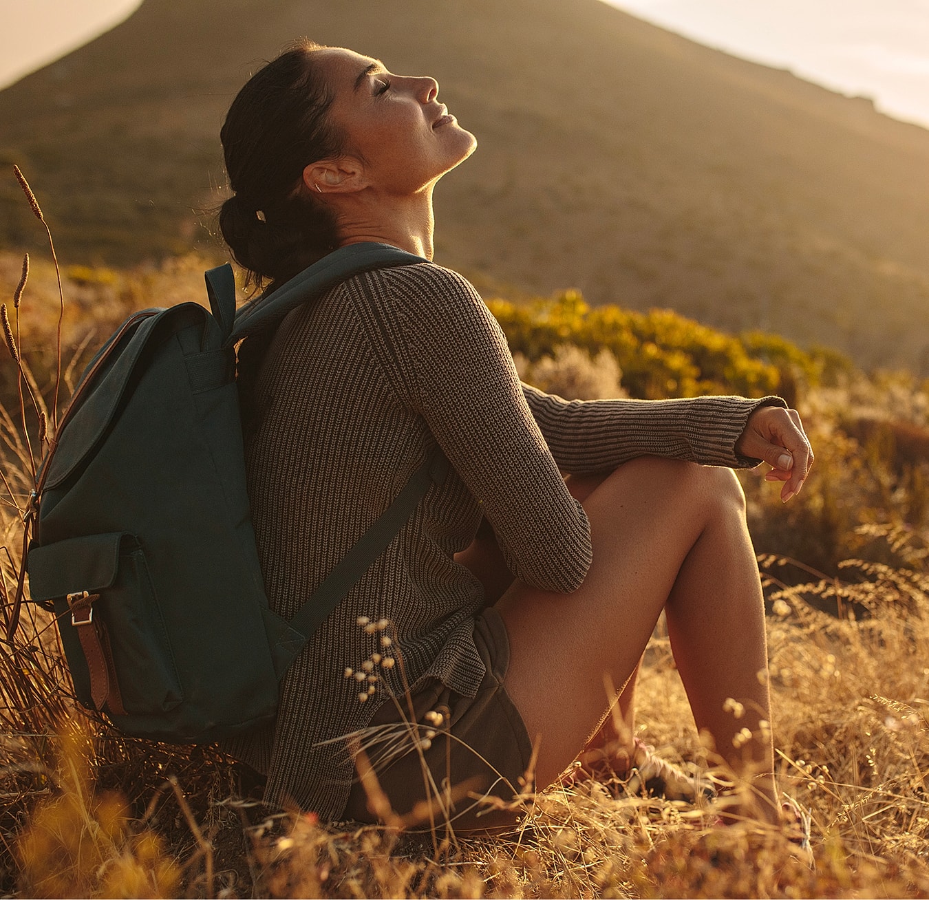 Woman enjoying nature during sunset outdoors.