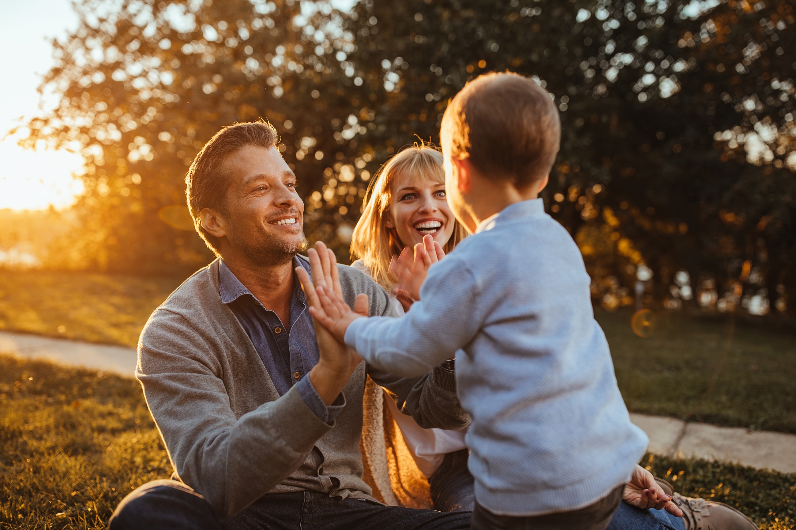 Family playing together outdoors at sunset.